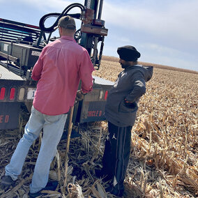 Researchers standing in field near truck