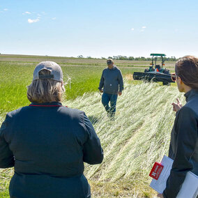Attendees gather around a roller crimper during a live demonstration at ENREEC.