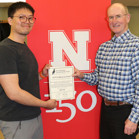 Xin Qiao (left), irrigation and water management specialist and principal investigator, and Jack Whittier, Panhandle Center Director of Research and Extension, accept the award from the Nebraska Environmental Trust fund to establish SDI research with livestock effluent.