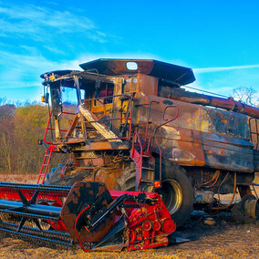 Burned combine in field