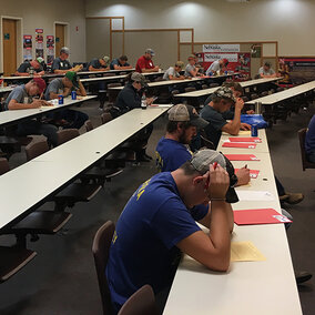 students taking a written test in a college classroom