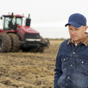 Photo of a farmer in contemplation in a field 