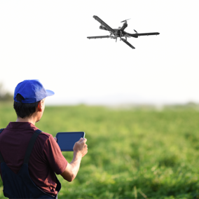 Farmer controlling drone over field