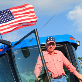 Farmer in tractor below flag