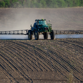 Tractor applying nitrogen fertilizer in bare soil field