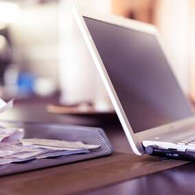 Photo of working with receipts and a home laptop computer