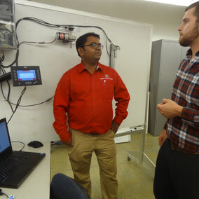 Biological Systems Engineering Assistant Professor Santosh Pitla (left) talks with BSE Graduate Student John Evans about the class they're teaching where students explore access and analysis of operational data from tractors. 