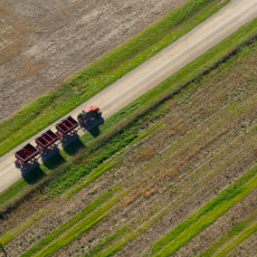 Tractor pulling grain carts down road