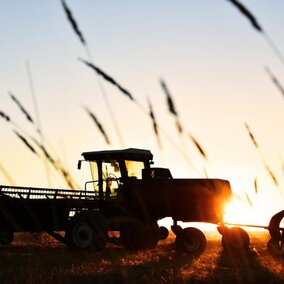 Tractor in field at sunset