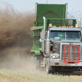 Truck spreader applying manure to field