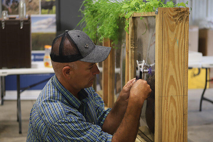 Marty Marx examines soil exhibit with phone attachment