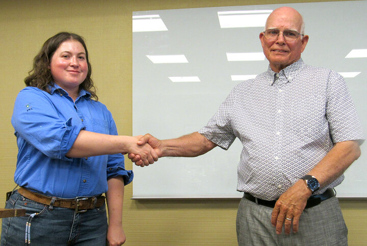 Two people shake hands toward camera