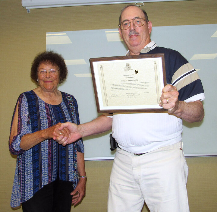 Two people shake hands toward camera