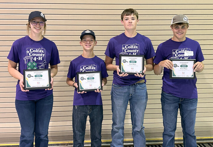 Four youths hold plaques