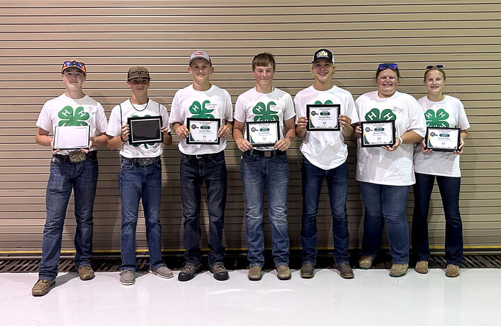 Team members hold plaques