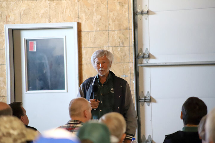 Man speaks at front of room to attendees