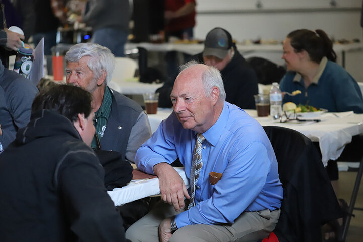 Two men speak at table