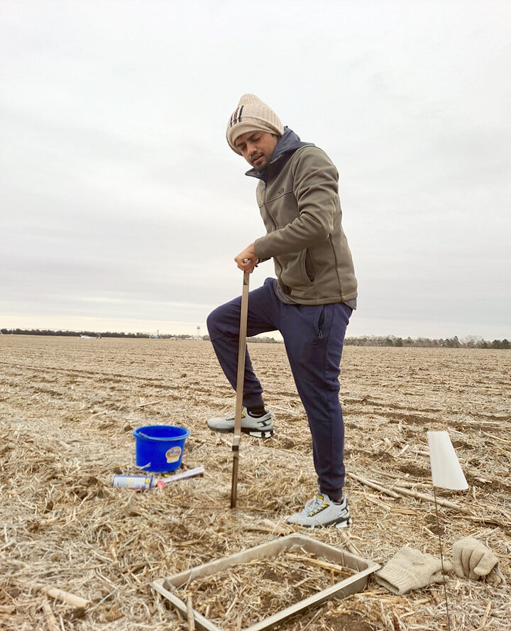 Man samples soil in field