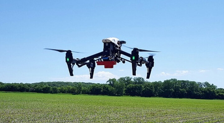 drone flying near field in blue sky