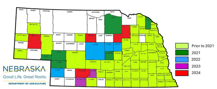 Color-coded Nebraska map showing the year Japanese beetles were first confirmed in each county. Most counties are shaded light green (prior to 2021), with scattered confirmations from 2021 to 2024 shown in dark green, blue, purple and red.