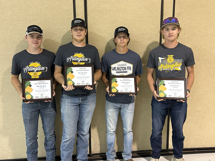 Four Arlington FFA members stand side by side holding first-place plaques from the Nebraska Youth Crop Scouting Competition.