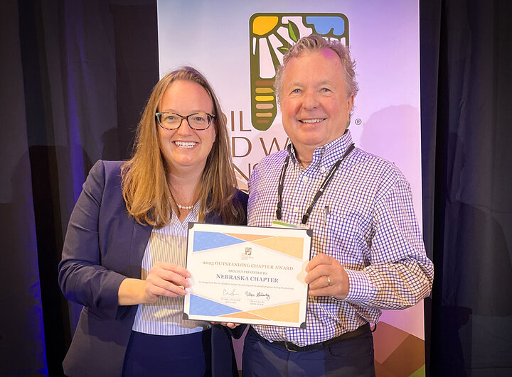 Chapter representative accepts the SWCS Outstanding Chapter plaque from the organization’s leader at the international conference.