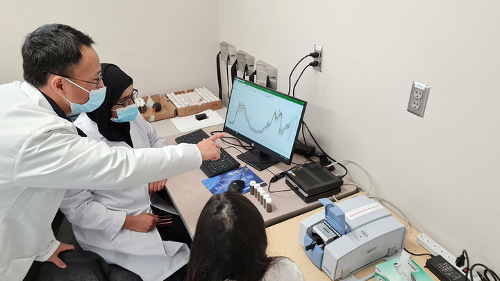Scientists analyzing data on a computer screen in a laboratory setting.