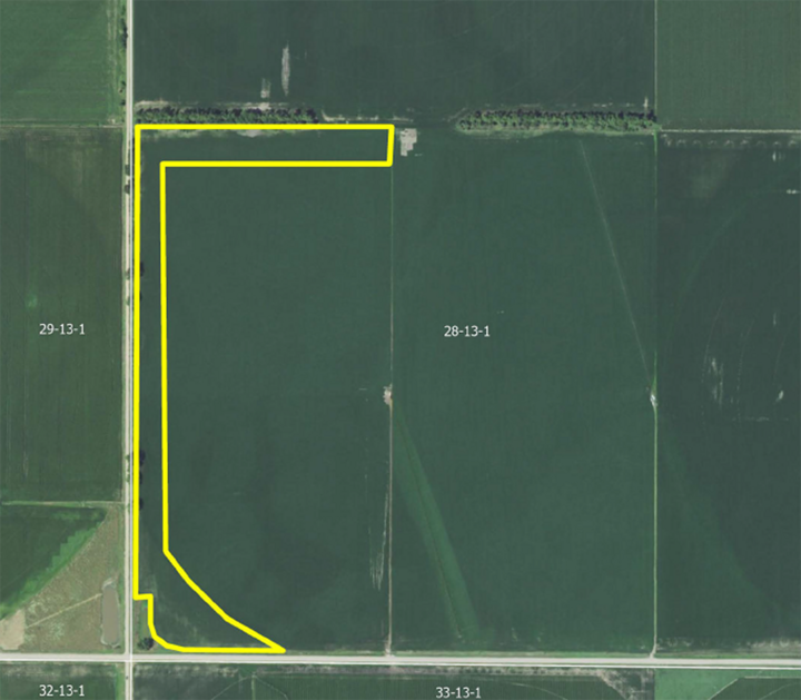 Aerial view of green farmland with a yellow outline indicating a specific section.