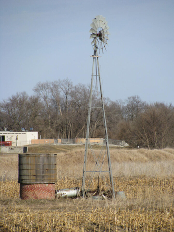 Photo of an unused well and windmill in a field