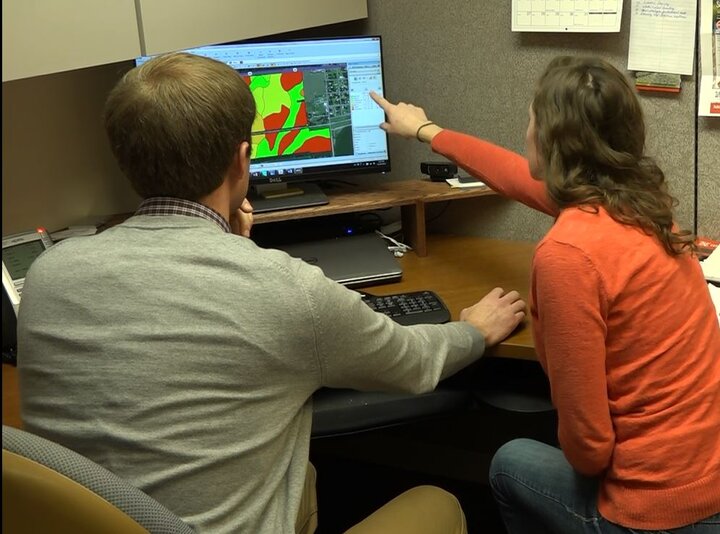 Producer and NU faculty reviewing precision ag data on a computer screen