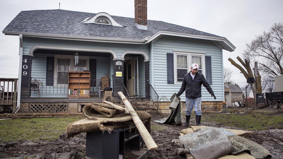 Connor Clark helps clear out the home of his grandfather, Dean Swim, in Winslow, Nebraska, on March 29, 2019.