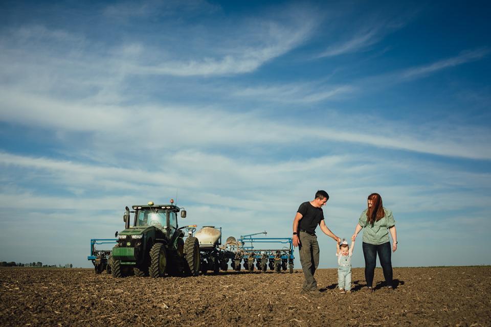 Farm couple with child in field