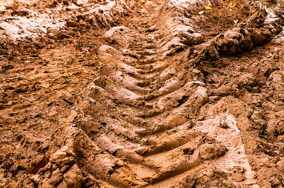 Tire tracks in muddy clay soil
