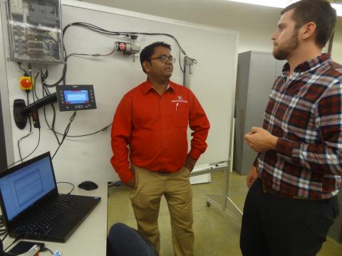 Biological Systems Engineering Assistant Professor Santosh Pitla (left) talks with BSE Graduate Student John Evans about the class they're teaching where students explore access and analysis of operational data from tractors. 