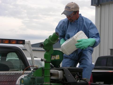 Photo of gloved pesticide applicator