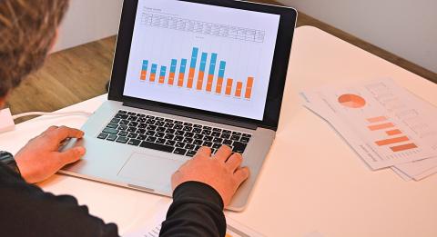 Entering financial data on a laptop