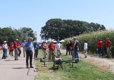 Field day participants inspect an ag drone