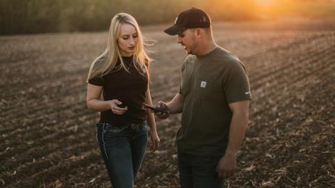 Young farm couple talking in field