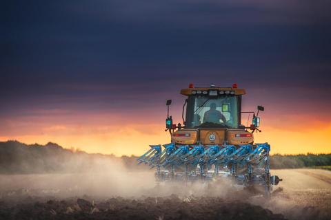 Tractor planting at sunset