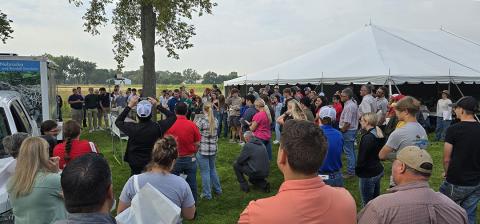 Large group of people surround Nathan Mueller during live rainfall simulation