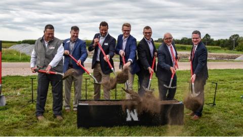 Men hold shovels behind ceremonial dig area