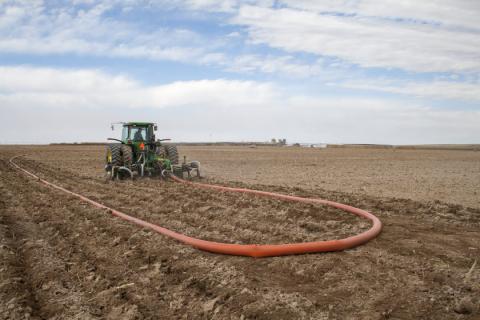 Tractor applies manure fertilizer to field