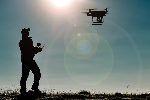 Man operates drone in field
