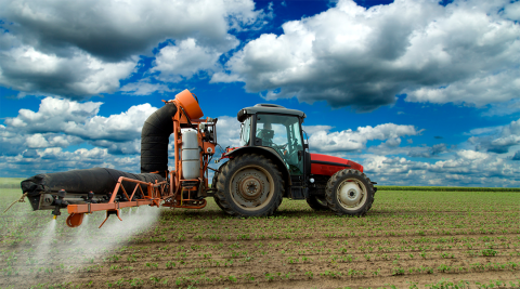 Tractor applying chemicals to soybean field