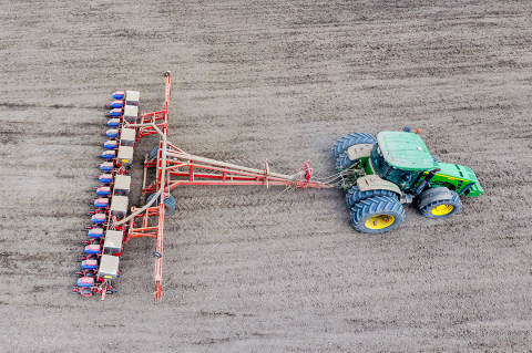 Tractor with seeder planting corn