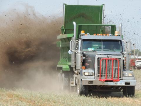 Truck spreader applying manure to field