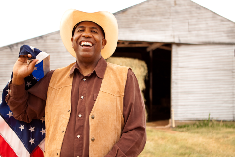 Man holding flag in front of barn