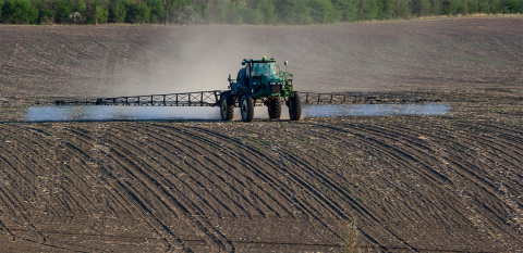 Tractor applying nitrogen fertilizer in bare soil field
